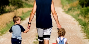 A dad walking with his two children